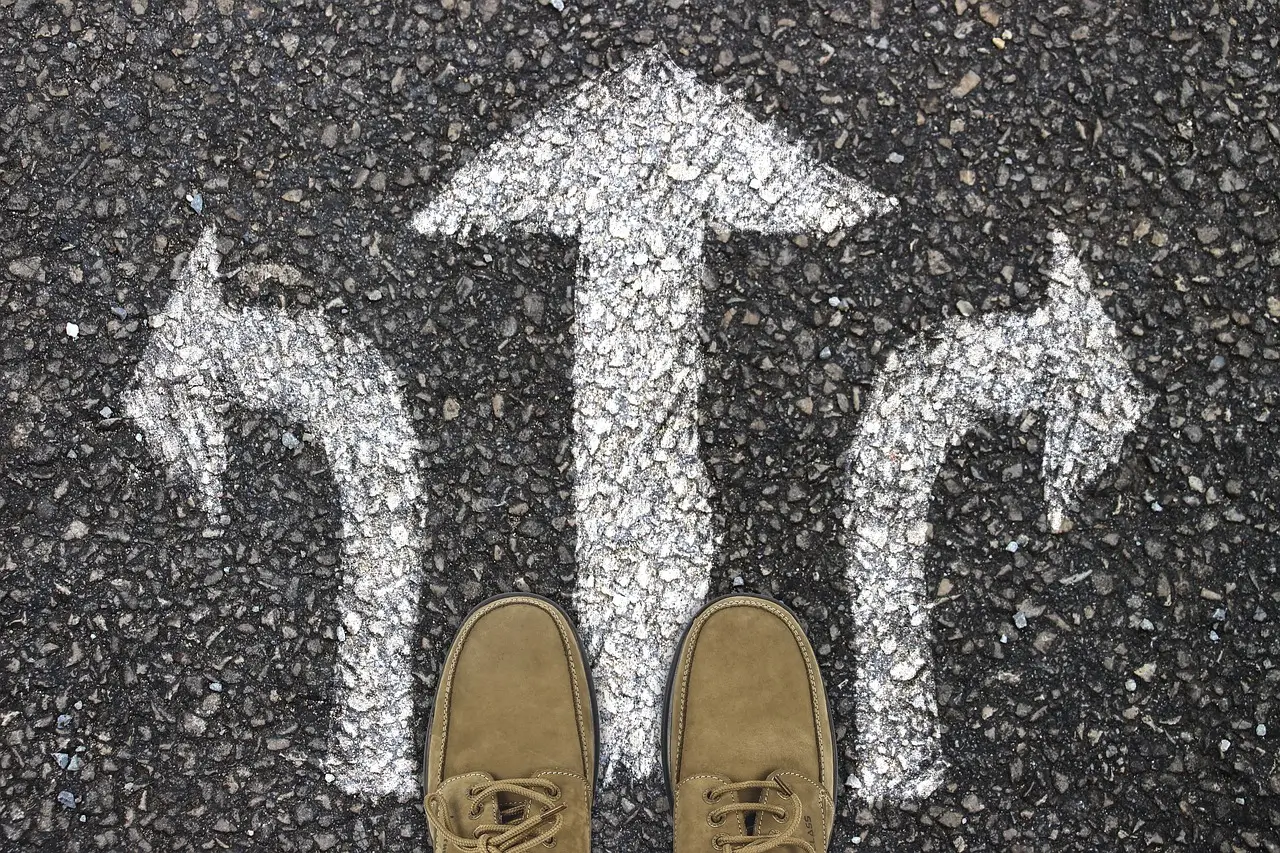 Feet on road with arrows pointing in different directions